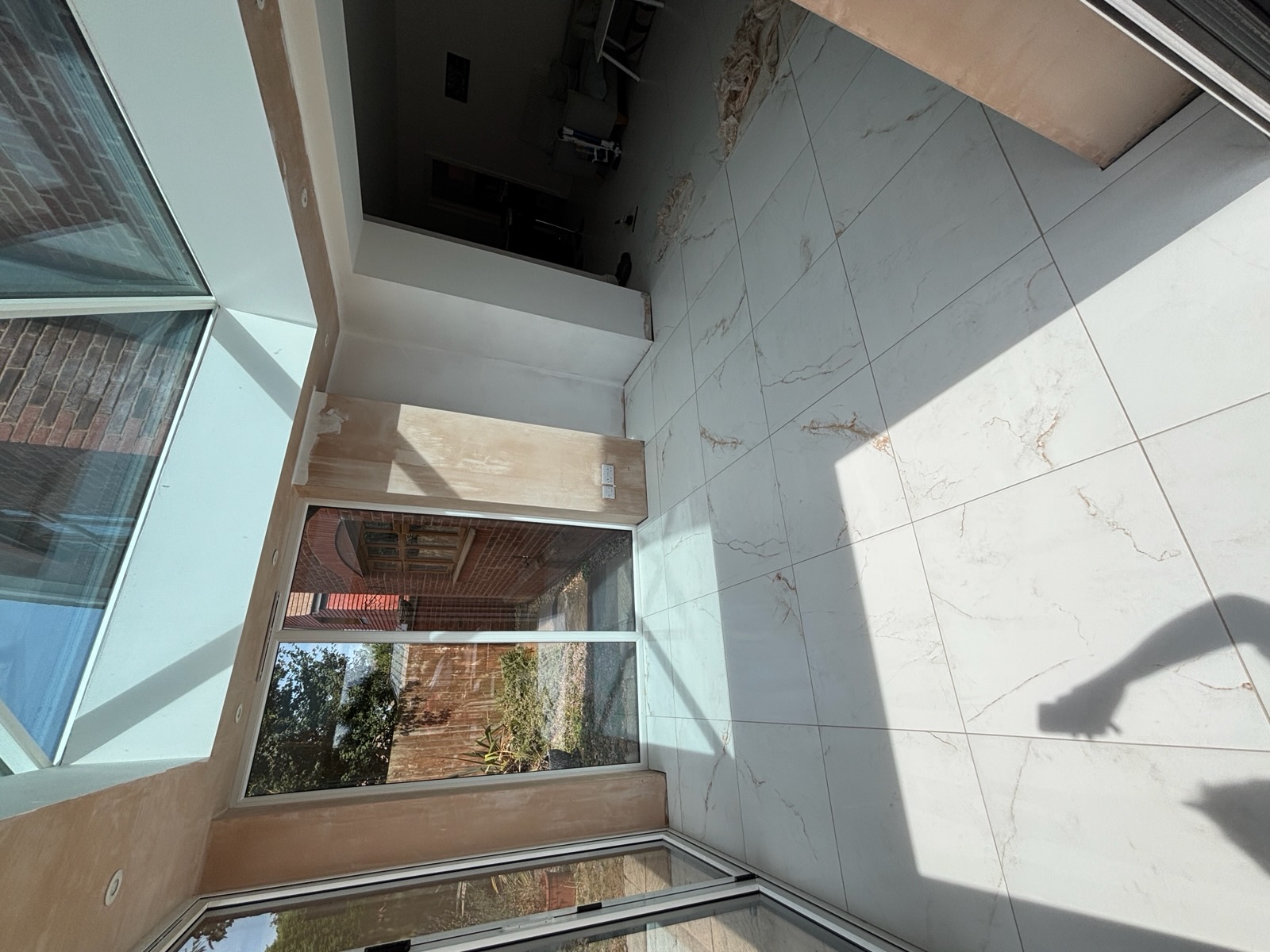 Large format marble-effect floor tiles in a bright glazed extension